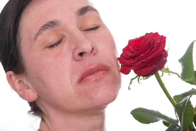 Primer plano de la cara de una mujer madura con una rosa Signos de envejecimiento de la piel después de los 40