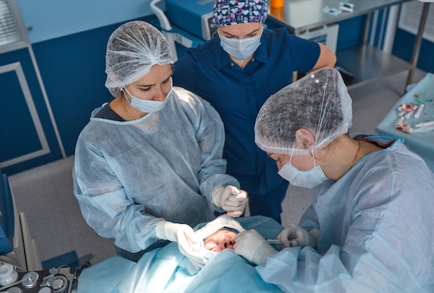 Foto primer plano de la cara de un paciente que se somete a una blefaroplastia el cirujano corta el párpado y realiza manipulaciones con instrumentos médicos