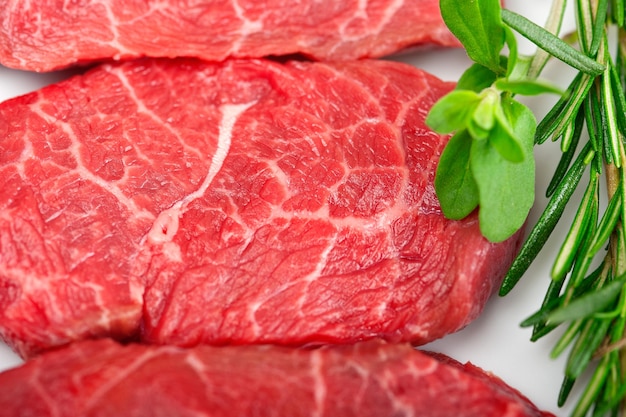 Primer plano de carne de res con hierbas en la mesa