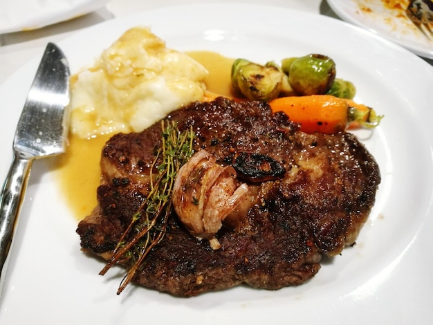 Primer plano de carne con verduras servidas en un plato