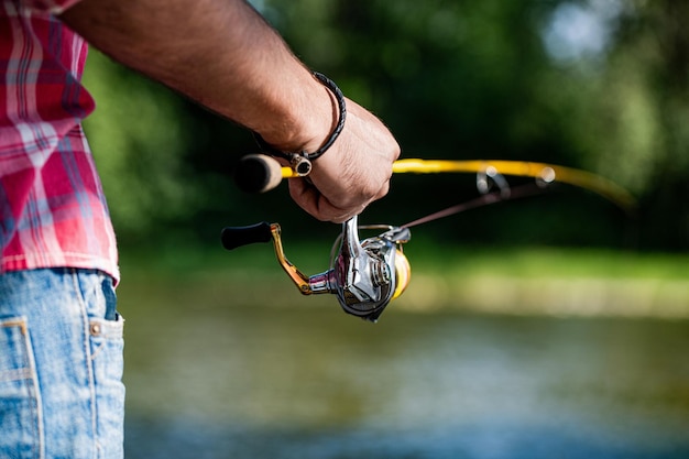 Primer plano del carrete de pesca en el fondo del río Carrete de pesca Caña de pescar con carrete de cuerpo de aluminio Aparejos de pesca Suministros y equipos para peces