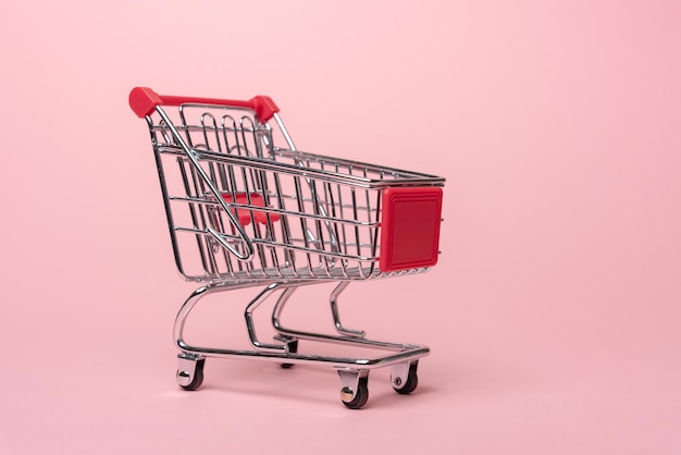 Primer plano del carrito de compras contra un fondo rosado
