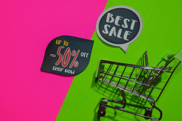 Primer plano del carrito de compras y las etiquetas en fondo de color