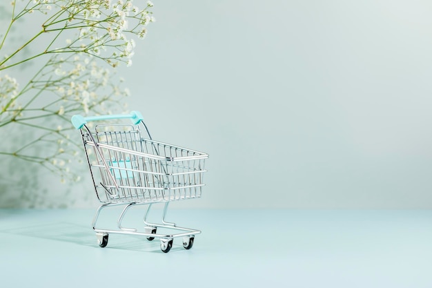 Primer plano de un carrito de compras en miniatura contra un fondo blanco