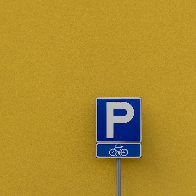 Primer plano del cartel contra la pared amarilla