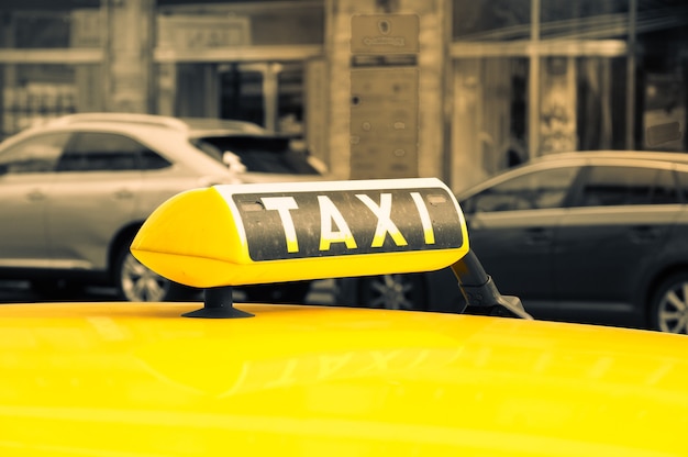 Primer plano de un cartel de taxi en un coche amarillo en una calle