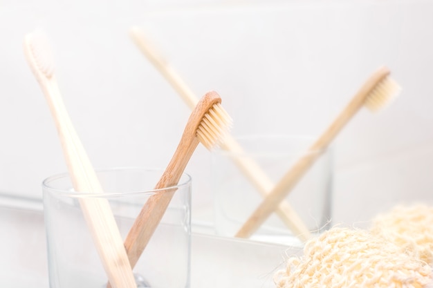 Primer plano del cepillo de dientes de bambú en un vaso en el baño. Residuos cero, eco, save planet, eco friendly