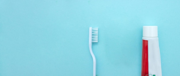 Primer plano de un cepillo de dientes y pasta de dientes sobre fondo azul borroso Higiene dental y tratamiento Concepto de dientes o dentaduras postizas sobre fondo azul