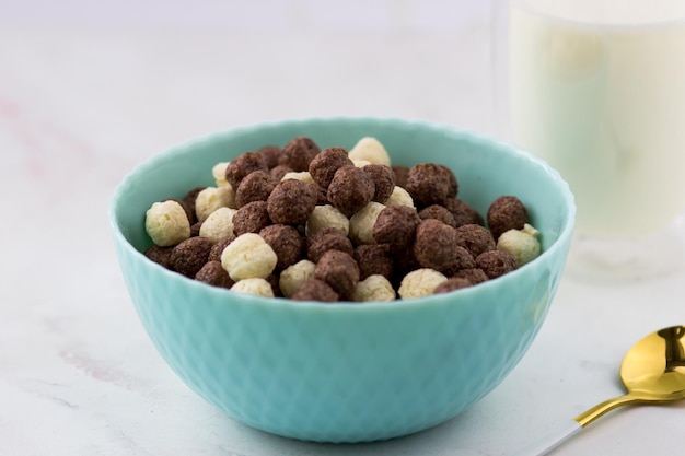 Primer plano de cereales para el desayuno Tazón de copos de maíz en una mesa de mármol blanco