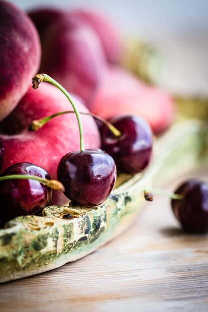 Foto primer plano de cerezas y melocotones en la mesa