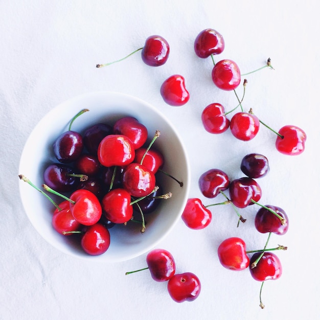 Primer plano de cerezas rojas sobre fondo blanco