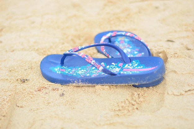 Foto primer plano de chanclas en la playa