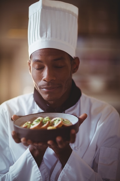 Primer plano del chef con los ojos cerrados oliendo comida