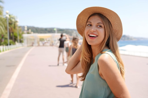 El primer plano de una chica elegante da la vuelta y mira hacia atrás en Promenade des Anglais Niza Francia