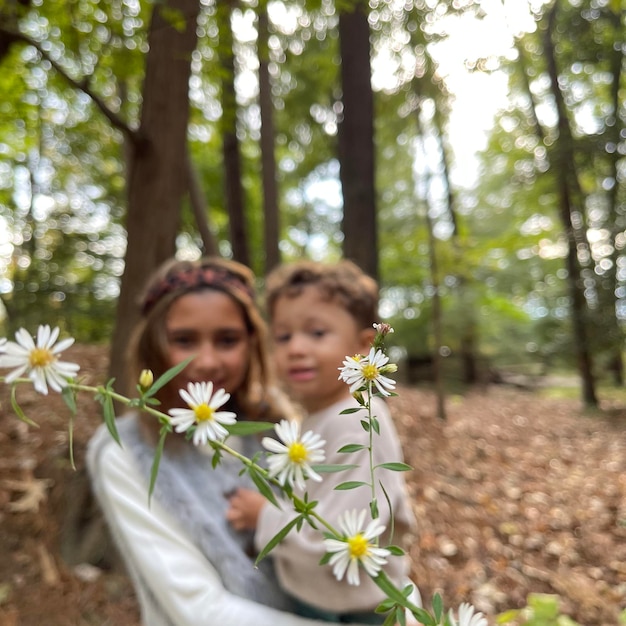 Foto primer plano de una chica con flores en el bosque