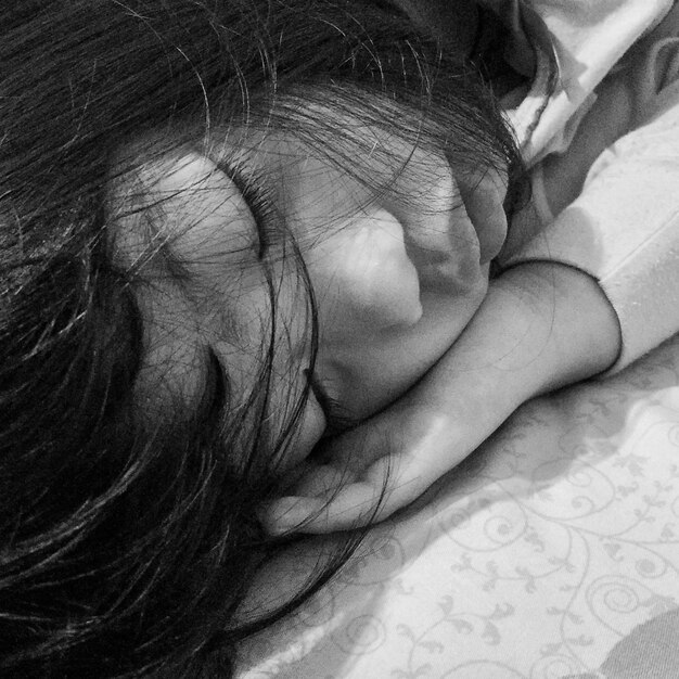 Primer plano de una chica linda durmiendo en la cama en casa