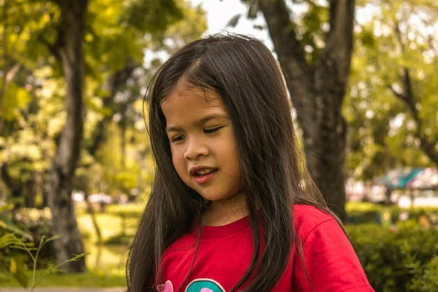 Foto primer plano de una chica linda de pie en el parque