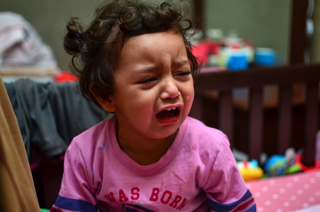 Foto primer plano de una chica llorando mientras está sentada en casa.