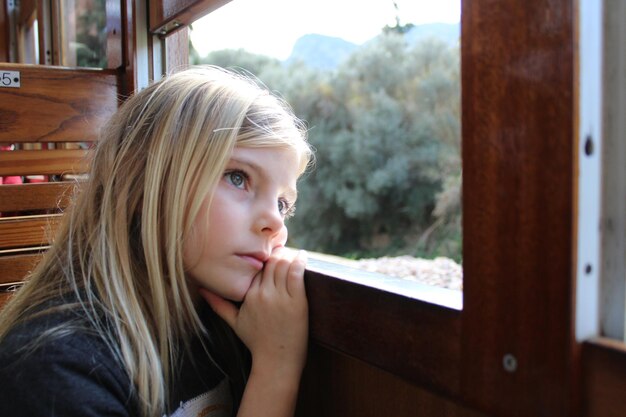 Primer plano de una chica mirando por la ventana