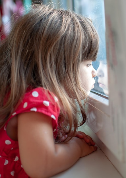 Primer plano de una chica mirando por la ventana
