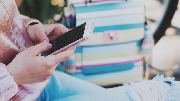 Foto primer plano de una chica usando un teléfono móvil