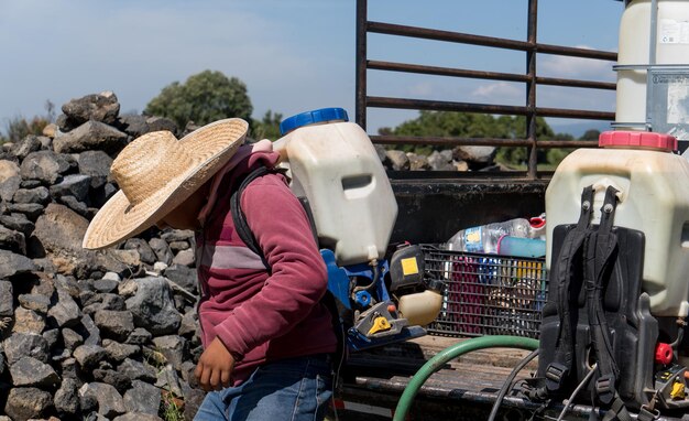 Primer plano de un chico con equipo para regar los campos