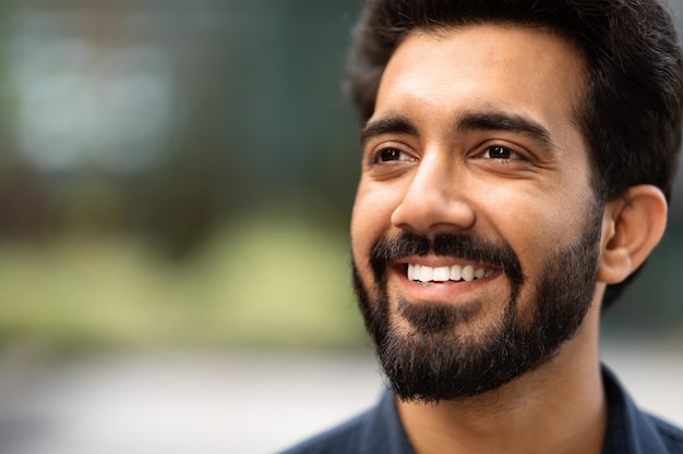 Primer plano de un chico indio guapo y alegre mirando el espacio de copia