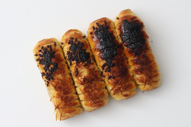 un primer plano de Chocolate Cheese Bolen hecho de chocolate de queso de harina con relleno de plátano servido en un estante de pasteles con fondo blanco aislado