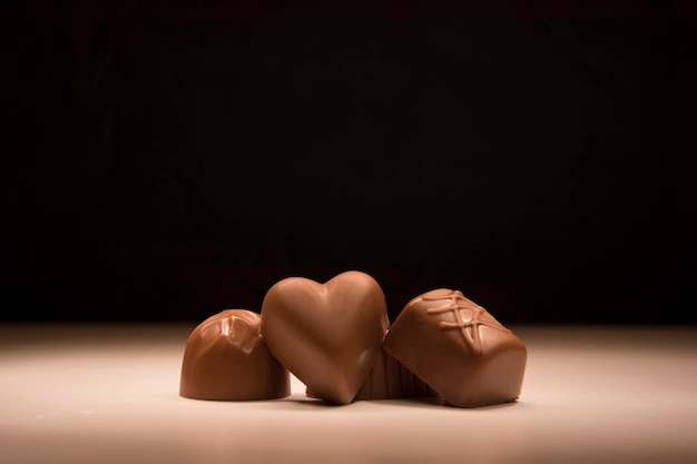 Foto primer plano de chocolates en la mesa contra un fondo negro