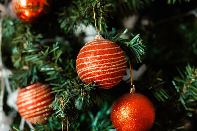 Primer plano de chuchería roja colgando de un árbol de Navidad decorado. Efecto de filtro retro.