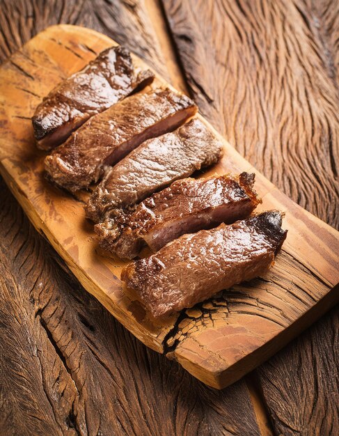 Foto primer plano de churrasco barbacoa brasileña sobre una mesa de madera comida de carne sabrosa comida deliciosa