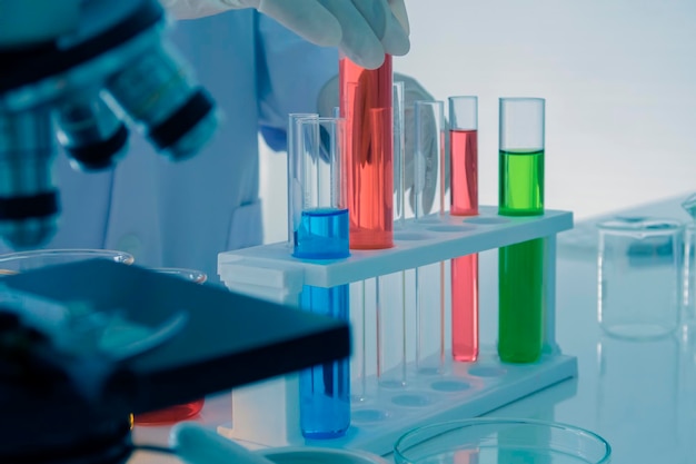 Primer plano de un científico realizando un experimento científico en vidrio de laboratorio