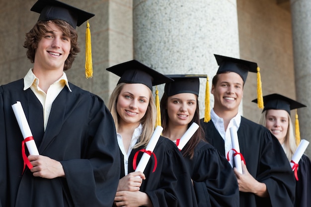 Primer plano de cinco graduados estudiantes posando