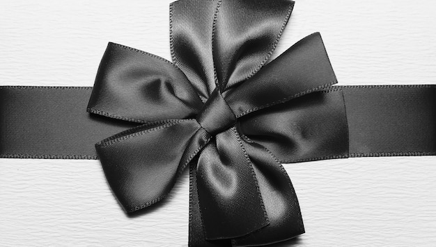 Primer plano de cinta de embalaje en blanco y negro en forma de lazo para caja de regalo.