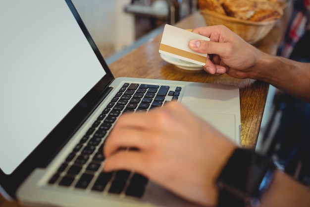 Primer plano del cliente gastando dinero en línea en el café