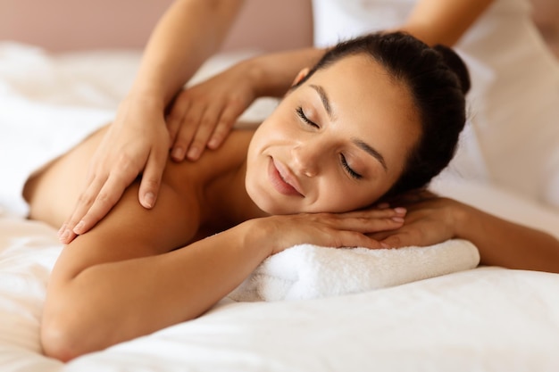 Primer plano de una cliente del spa recibiendo un masaje terapéutico relajante
