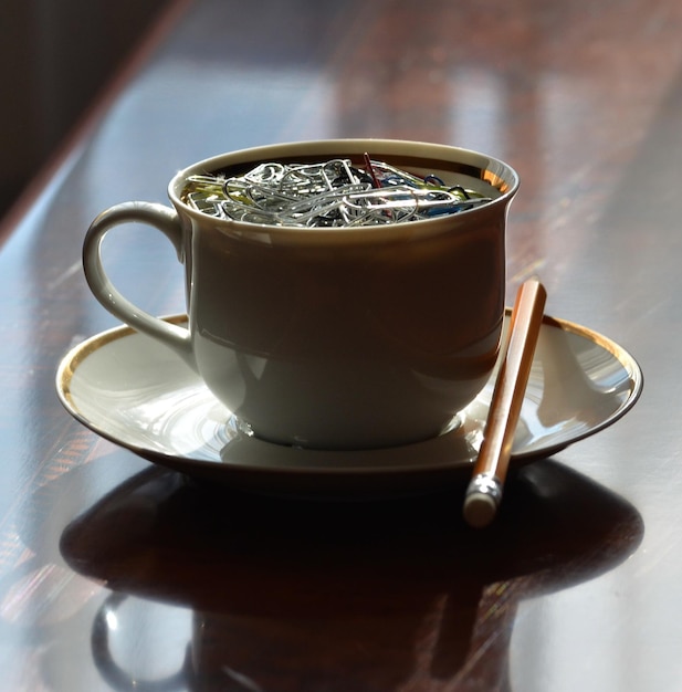 Primer plano de clips de papel en una taza sobre la mesa