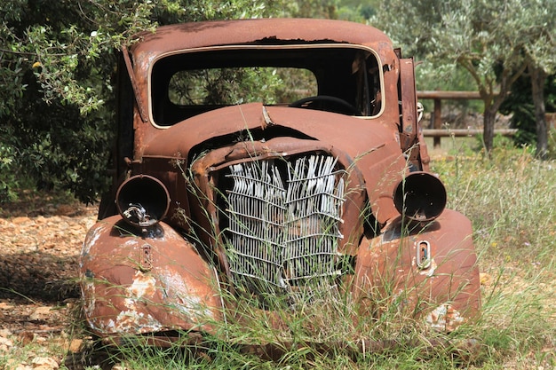 Foto primer plano de un coche abandonado en el campo