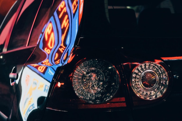 Primer plano de un coche en una ciudad iluminada por la noche