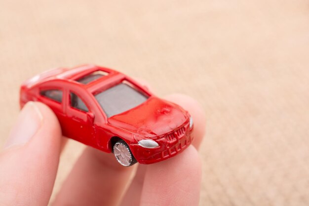 Foto primer plano de un coche de juguete cortado que se sostiene con la mano