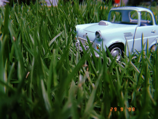Foto primer plano de un coche de juguete en un terreno cubierto de hierba