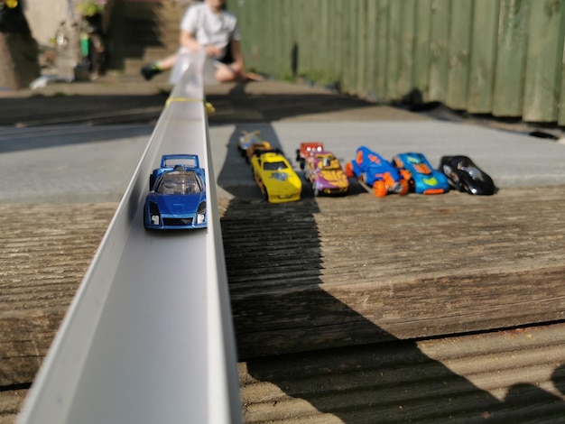 Primer plano de un coche de juguete en la vía con un niño detrás