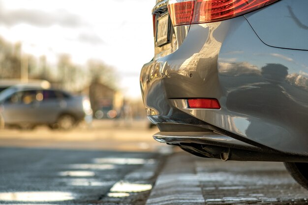 Primer plano de un coche moderno estacionado a un lado de una calle de la ciudad.