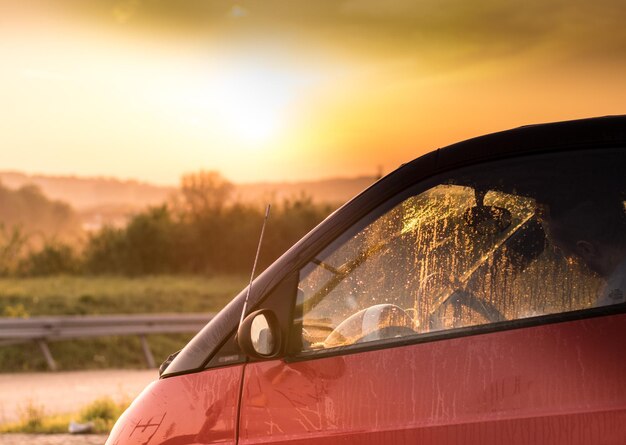 Foto primer plano de un coche naranja contra el cielo al atardecer