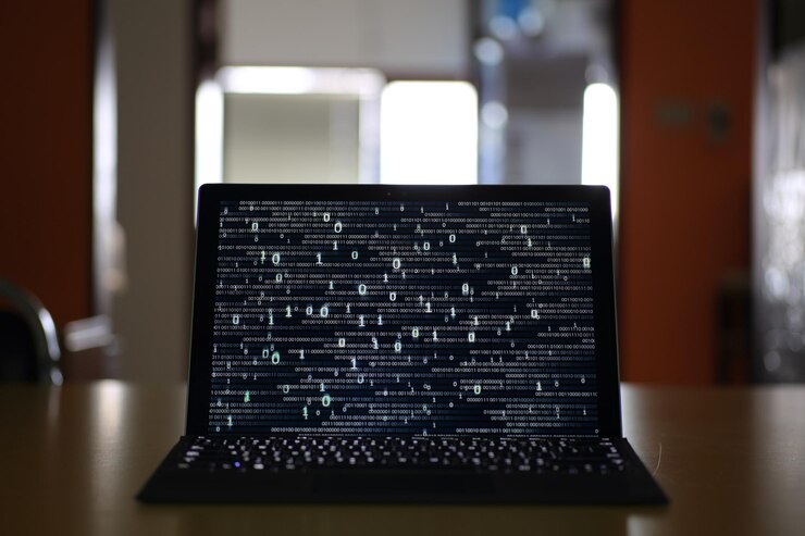 Foto primer plano del código binario en la pantalla del portátil en la mesa
