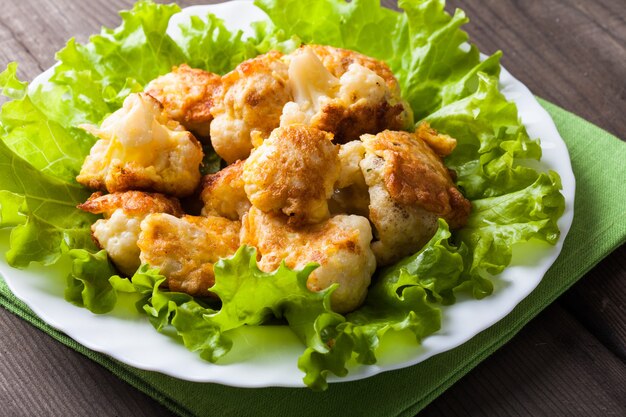 Primer plano de coliflor frita en el plato sobre una mesa