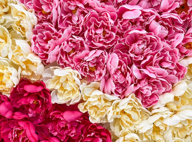 Primer plano de las coloridas flores artificiales de la tela, en la pared del centro comercial decorado en el festival