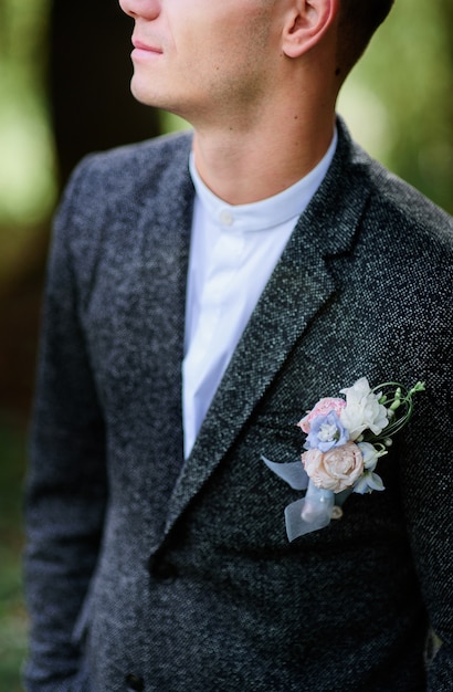 Primer plano de colorido pinout boutonniere a la chaqueta gris del novio