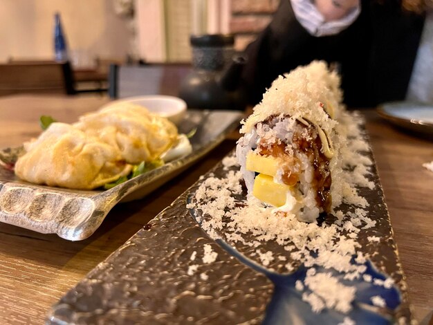 primer plano de comida japonesa en un restaurante mango nigiri con queso rallado