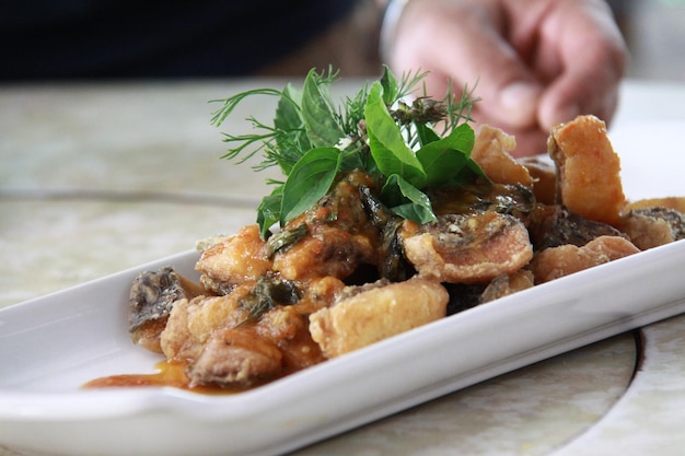 Primer plano de la comida con la mano en la mesa